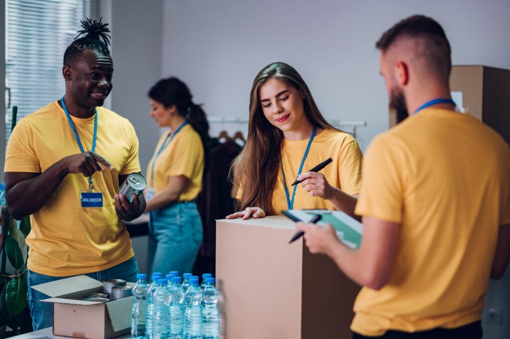 Group of multiracial volunteers working in community charity donation center